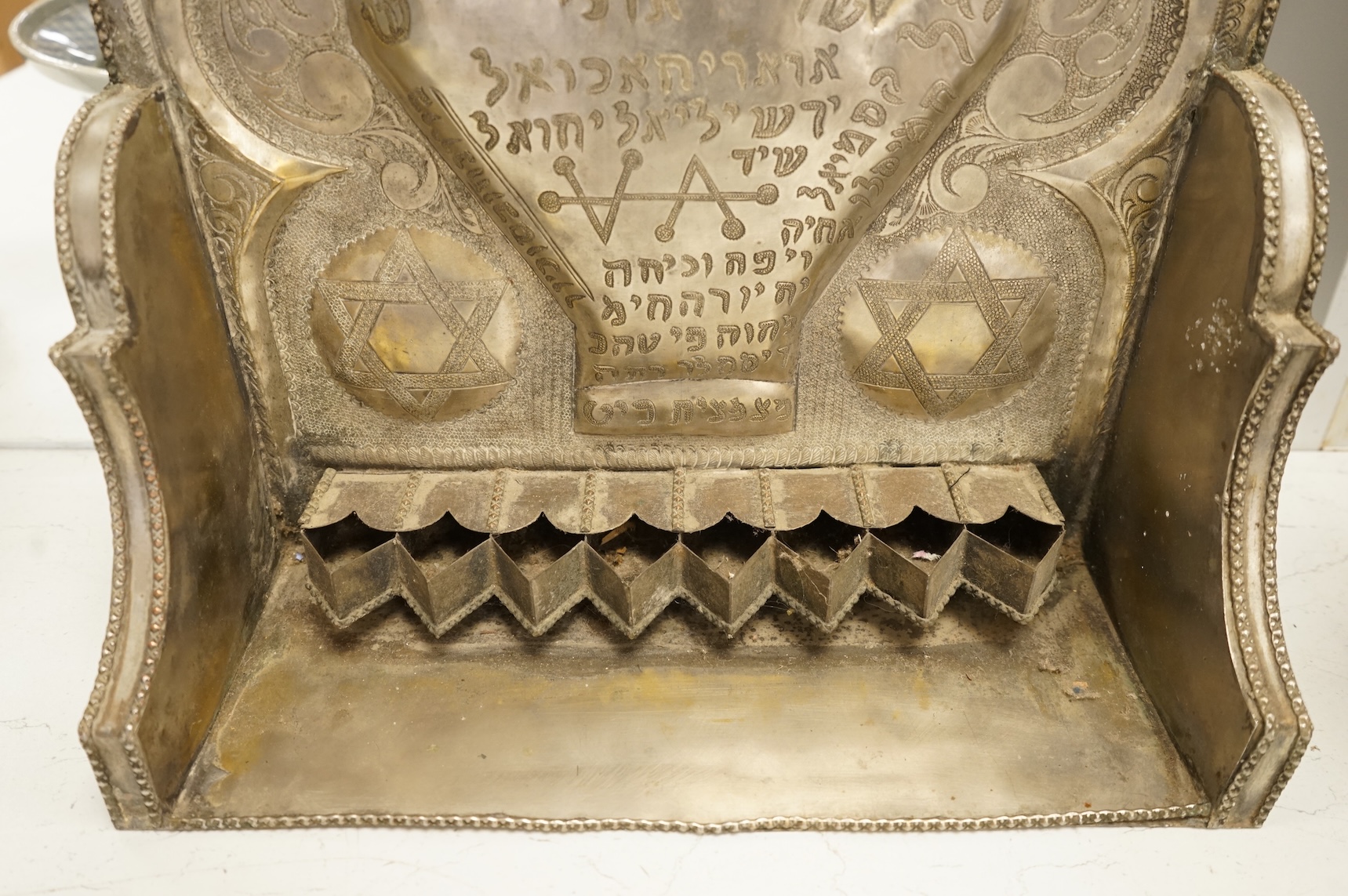 A Jewish embossed white metal menorah, 51cm high
